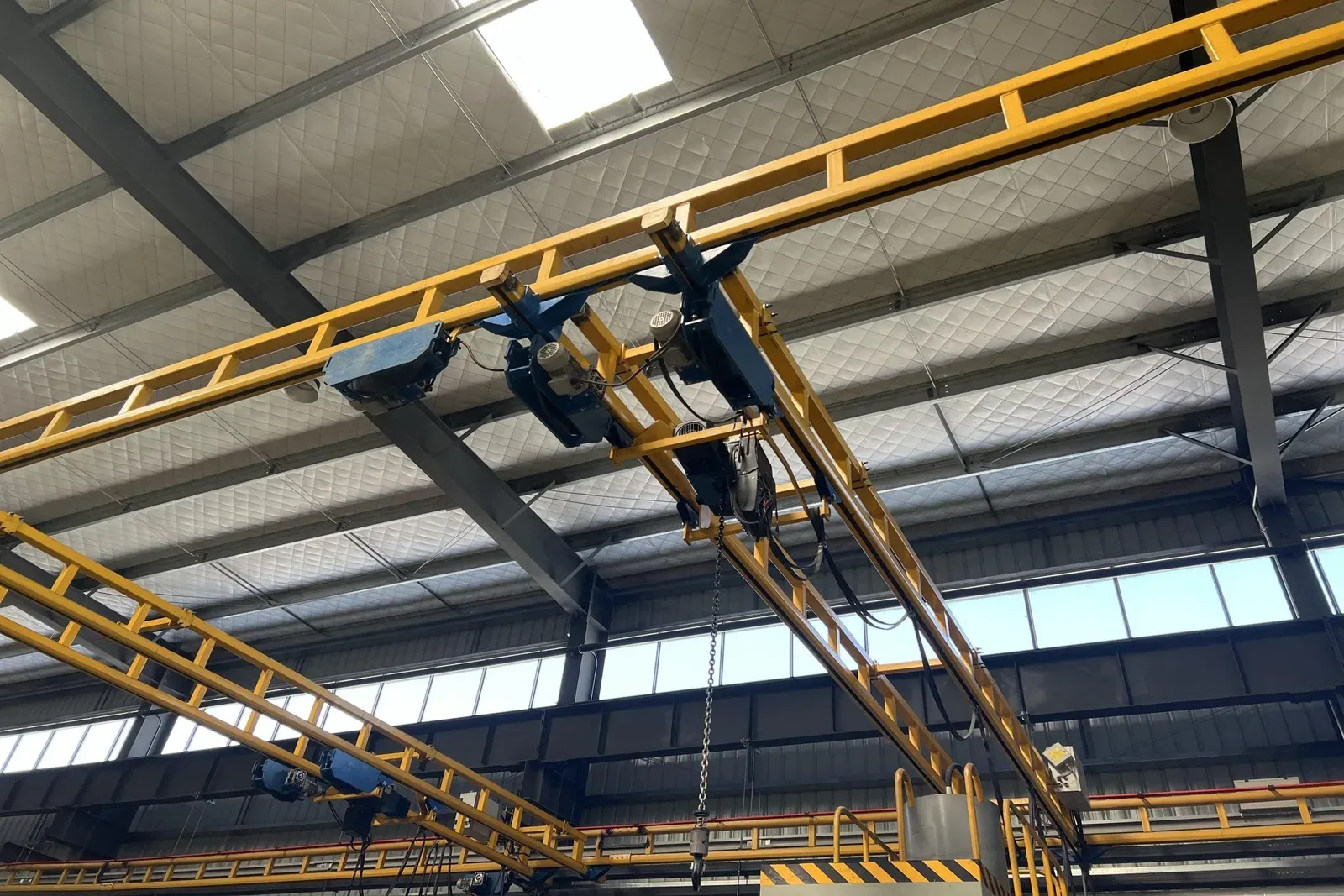 Rigid double-girder bridge crane and travel assemblies